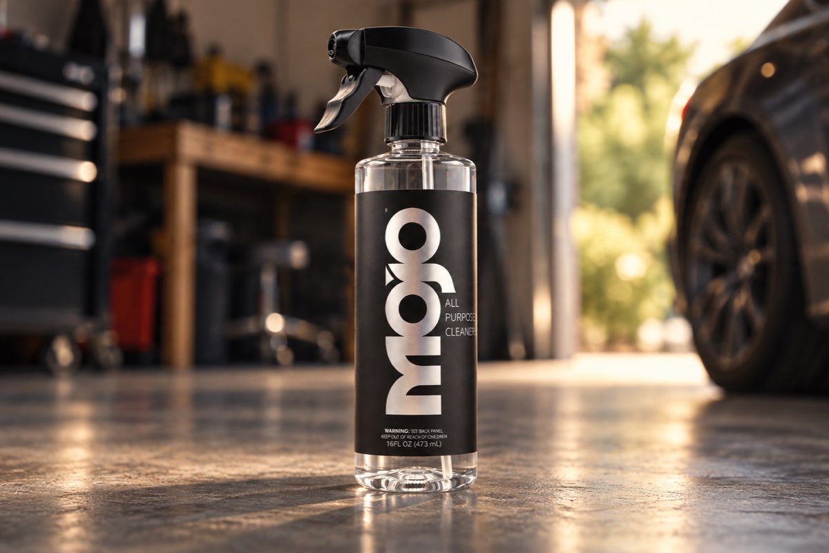 The MOJO bottle on a garage floor, with a tool chest and a car behind it.